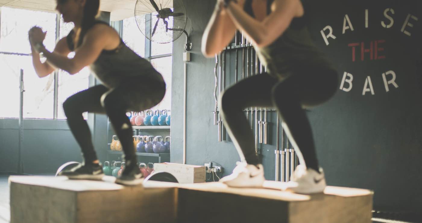 Hintergrundbild einer Gruppe von Fitnessstudio Mitgliedern, die einen Athletik Training Kurs besuchen